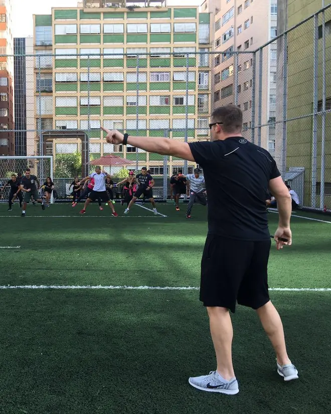 Fernando Jaeger conduzindo treino em grupo em campo de futebol