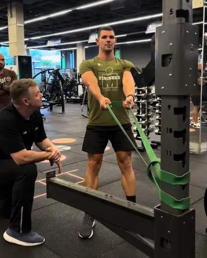 Fernando Jaeger acompanhando aluno em exercício com elástico